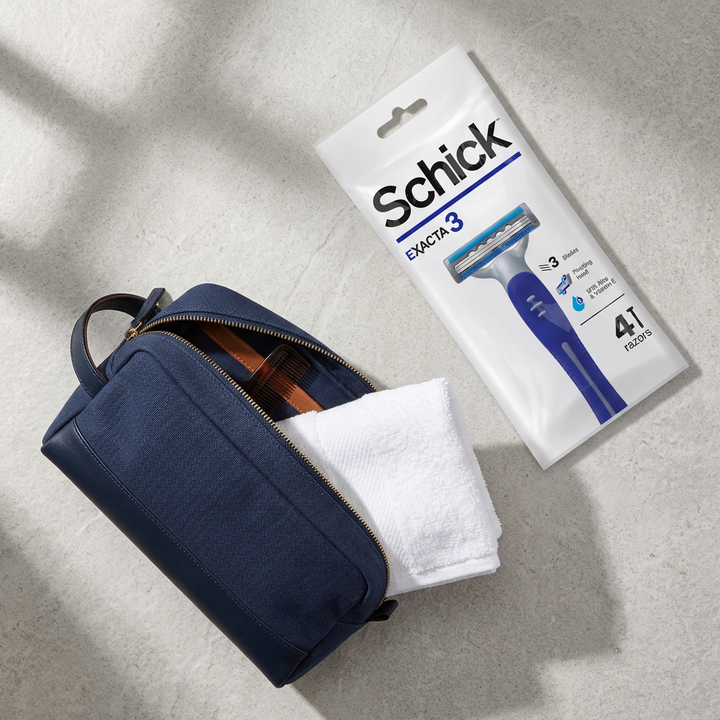 Overhead flatlay of Schick Exacta3 pack with a navy travel toiletry bag