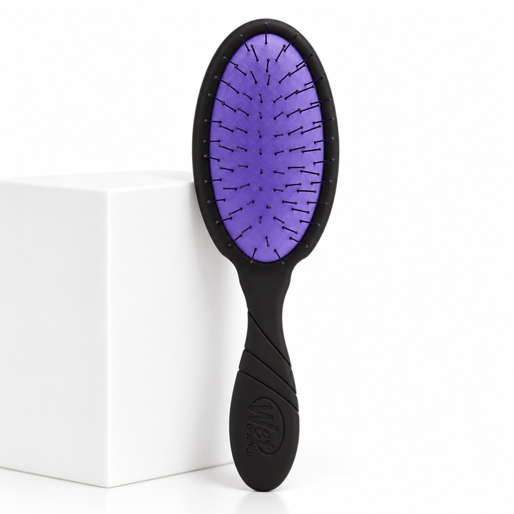 Black and purple Wet Brush Thin Hair beside a white plinth