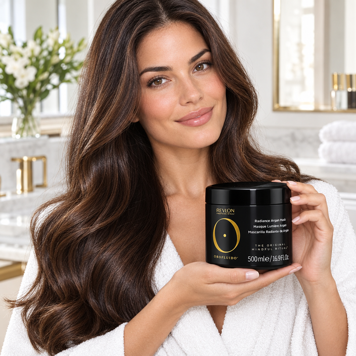 Model holding the Orofluido Radiance Argan Mask jar beside long hair