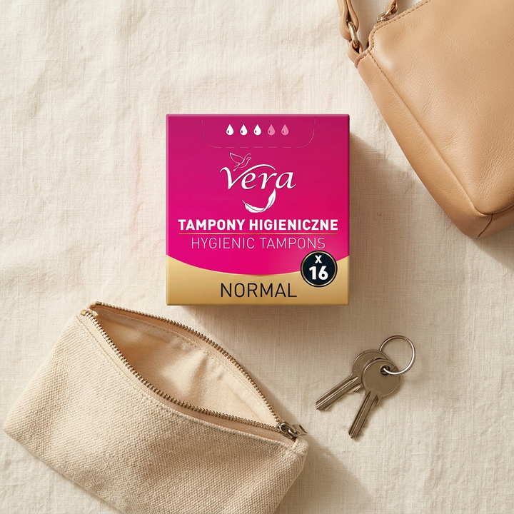 Overhead flatlay of Vera Normal 16-piece box beside a small pouch and handbag