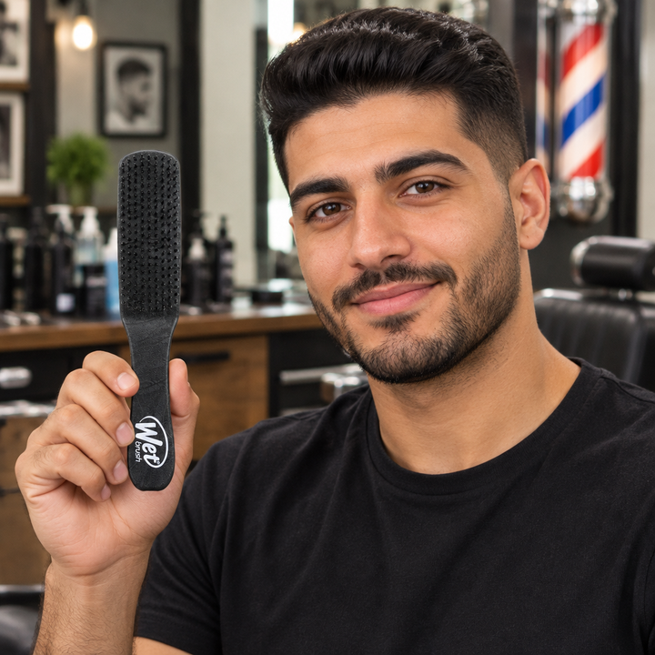 Man holding black WetBrush Styler for Men in barbershop