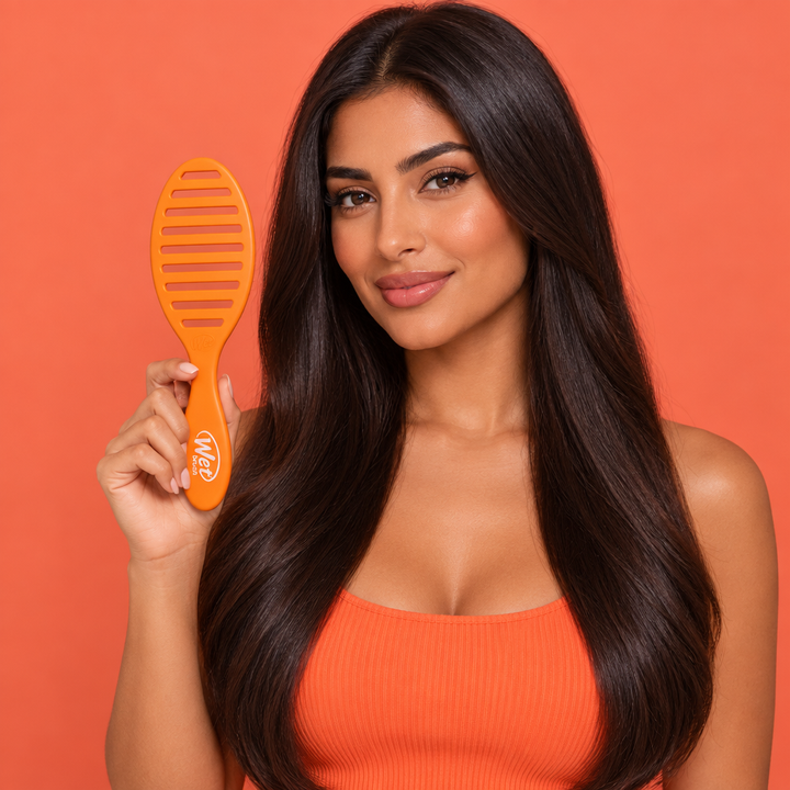 Model holding orange Speed Dry brush with back facing camera