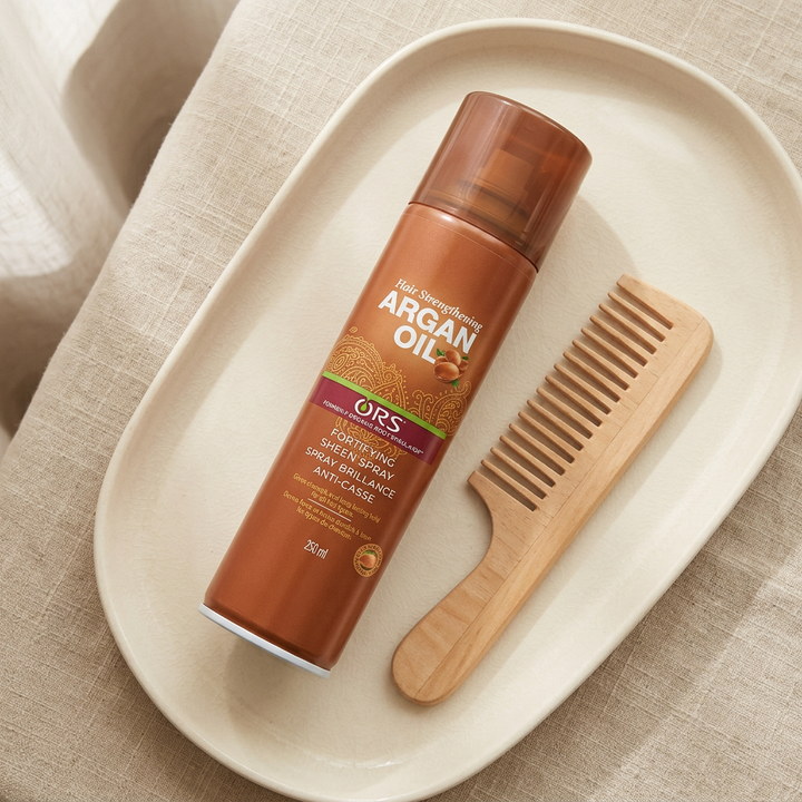 ORS Argan Oil Spray with wooden comb on ivory vanity tray